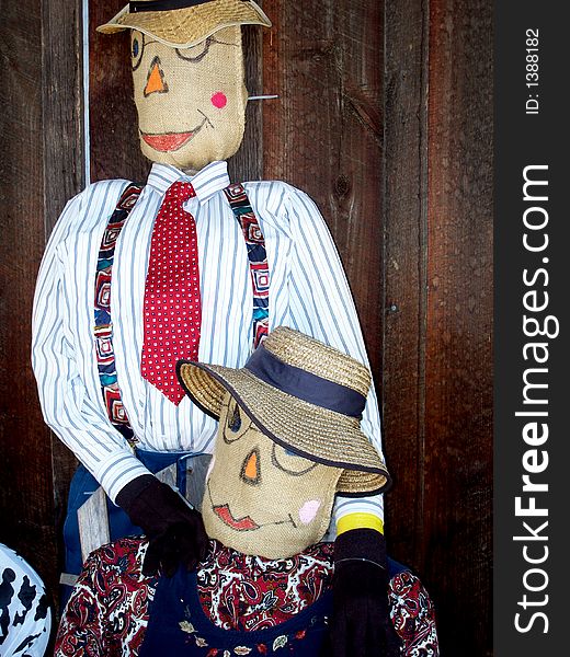 Two scarecrows dressed up - one as dad and one as mom. Two scarecrows dressed up - one as dad and one as mom