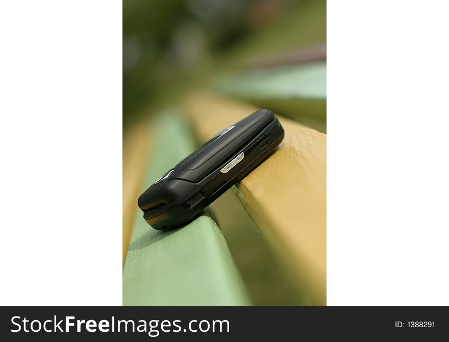 Mobile phone on the rainbow colored bench