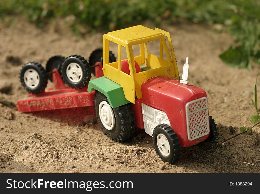 A forgotten colored toy vehicle on the sand