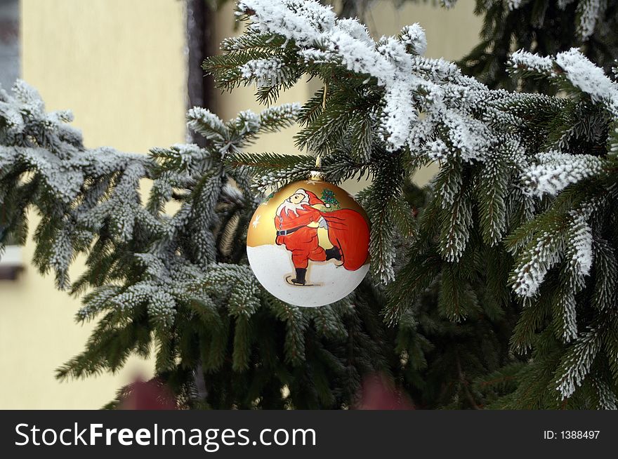 Christmas decoration - glass ball on spruce with snow-