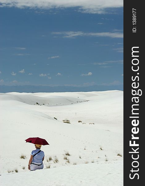 Woman sitting on white sand dunes