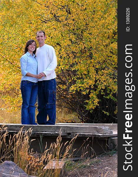 Couple portrait hugging and laughing with trees behind