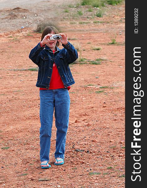 Young girl holding camera taking pictures. Young girl holding camera taking pictures