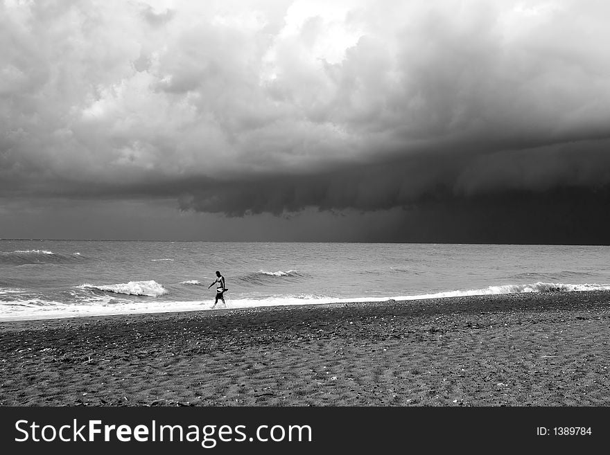 A lone swimmer on a stormy day, with dramatic sky.Black and White. A lone swimmer on a stormy day, with dramatic sky.Black and White.