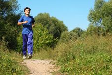 Man Wearing Sporty Clothes Is Running Along Path Stock Photography