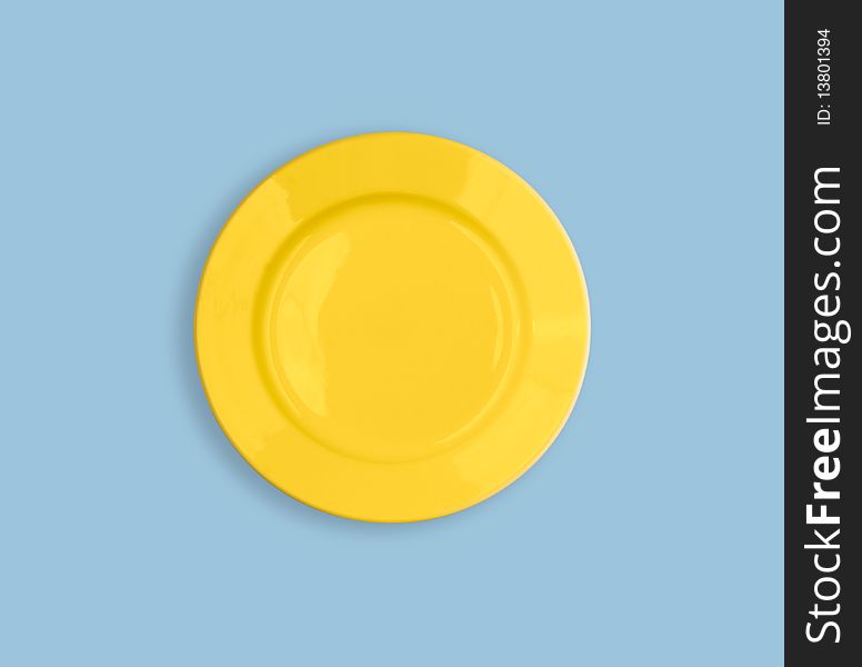 Yellow round plate on sky blue background. Yellow round plate on sky blue background