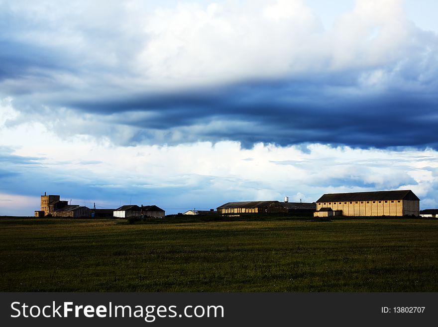 Agricultural farm in the field under clouds. Agricultural farm in the field under clouds