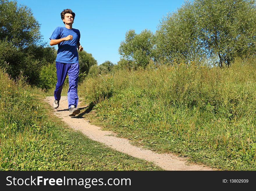 Sunny summer day. one man wearing sporty clothes is running.