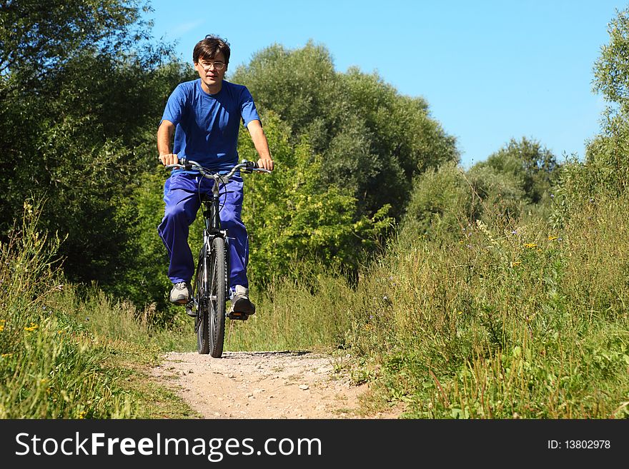 Man wearing sporty clothes is riding on bycicle