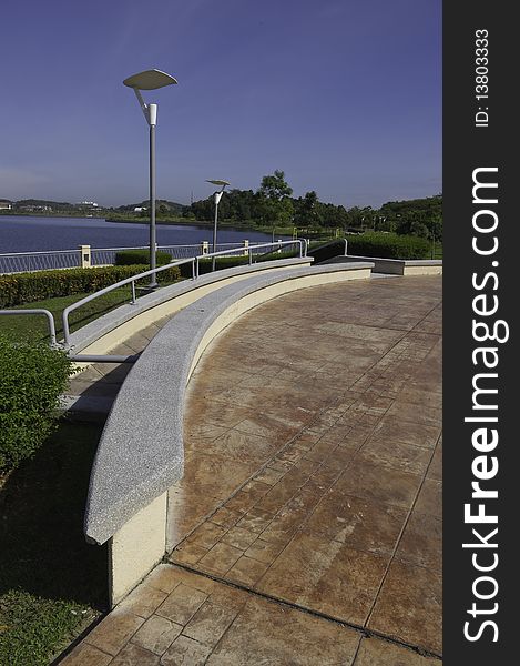 Curving bench constructed from concrete and finished by granite sprayed tile on the lakeside promenade