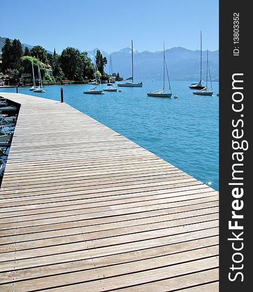 Wooden pier against lake Thun and Alps. Switzerland