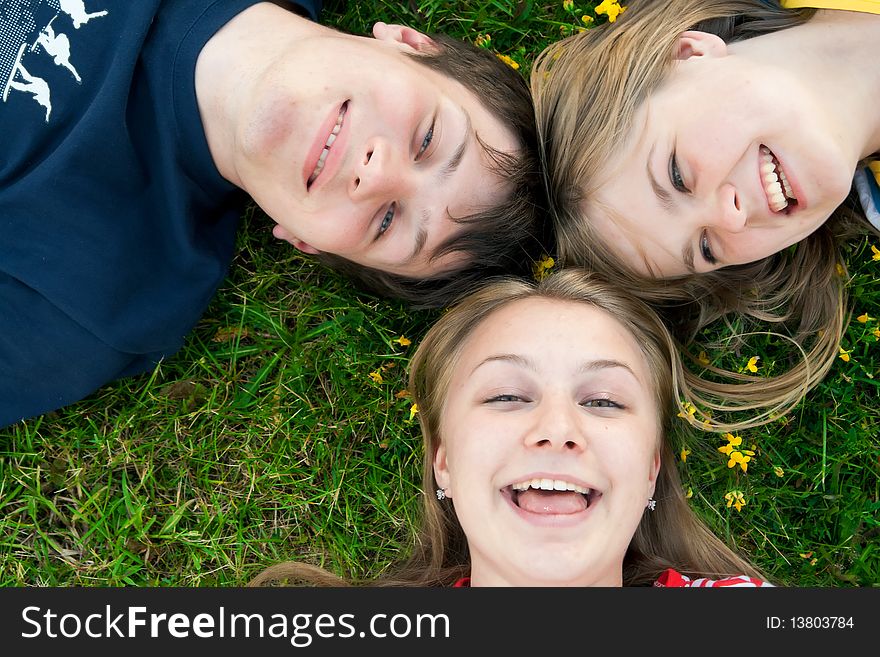 Three happy friends lay on a grass. Three happy friends lay on a grass