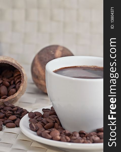 Coffee cup with roasted coffee beans, close-up