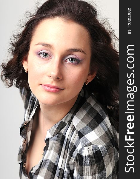 Portrait of the young beautiful girl with radiant eyes in a checkered shirt