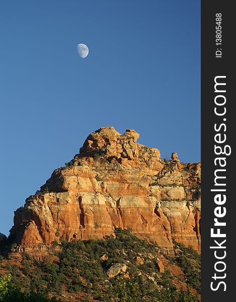 The half-moon was rising early over the red rocks of Sedona, Arizona. The half-moon was rising early over the red rocks of Sedona, Arizona.