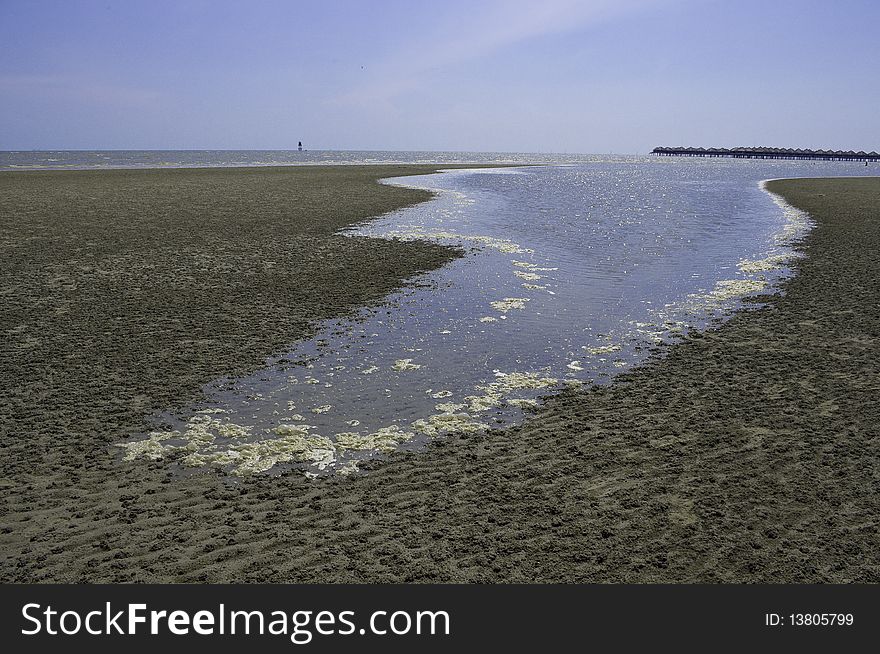 Tide water moving on textured sandy beach. Tide water moving on textured sandy beach