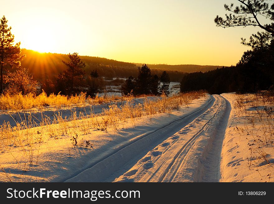 Sunset in the field in the winter, snowy road and the sky. Sunset in the field in the winter, snowy road and the sky