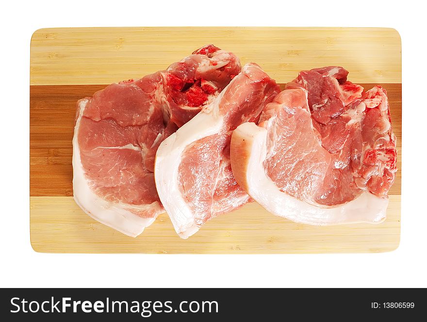 Raw pork on wooden cutting board. Isolated on white background with clipping path