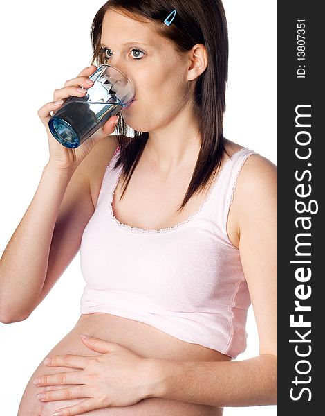 Thirsty pregnant girl drinking water with one hand on her belly