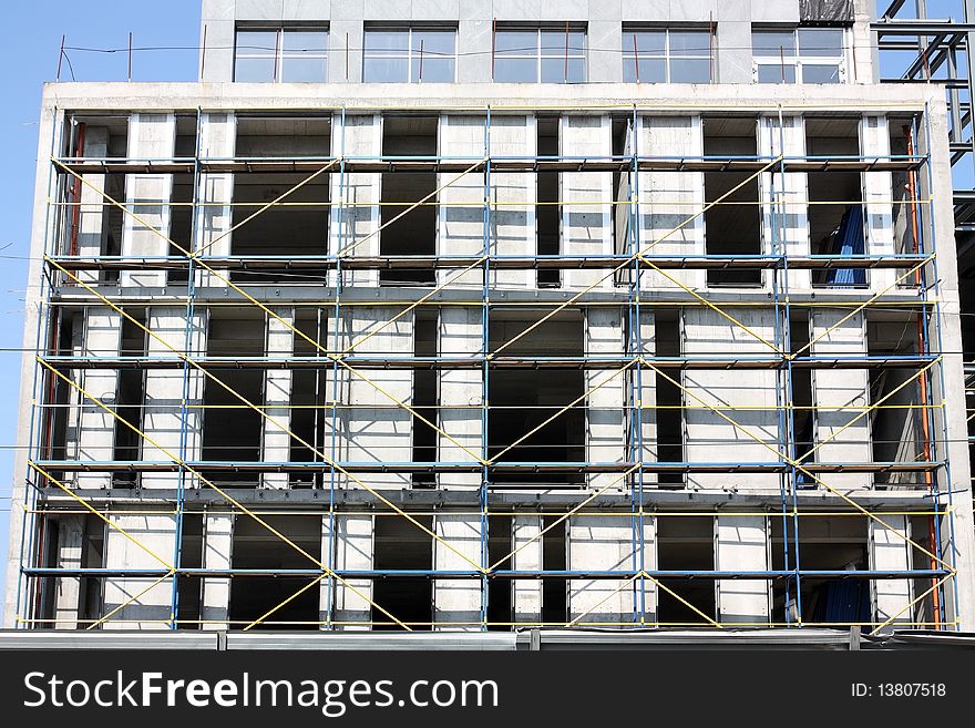 The unfinished concrete building furnished scaffolding. The unfinished concrete building furnished scaffolding