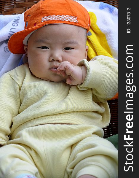 Cute baby with orange cap.