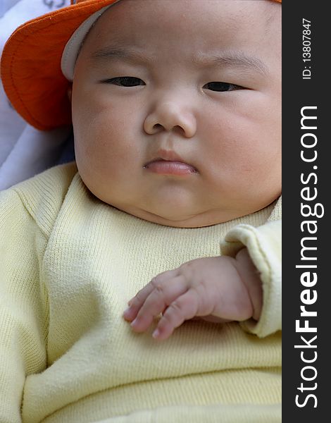 A cute baby with a orange cap.