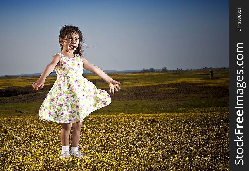 Little girl laughing in a field of yellow flowers. Little girl laughing in a field of yellow flowers