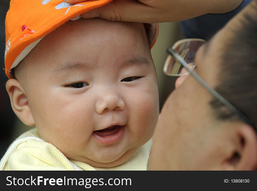 A cute baby with a orange cap.