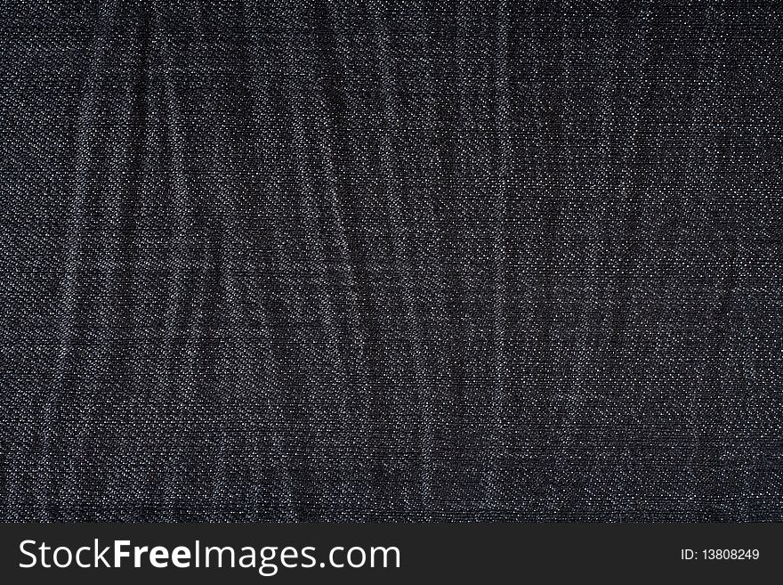 Wrinkled black jeans close up