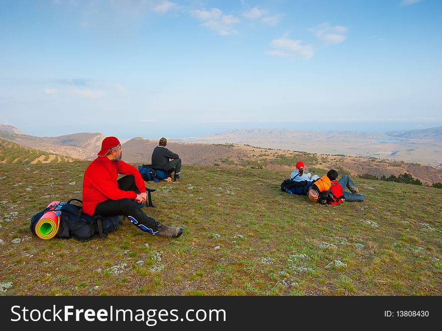 Hikers sit on the slope and enjoy the scenery