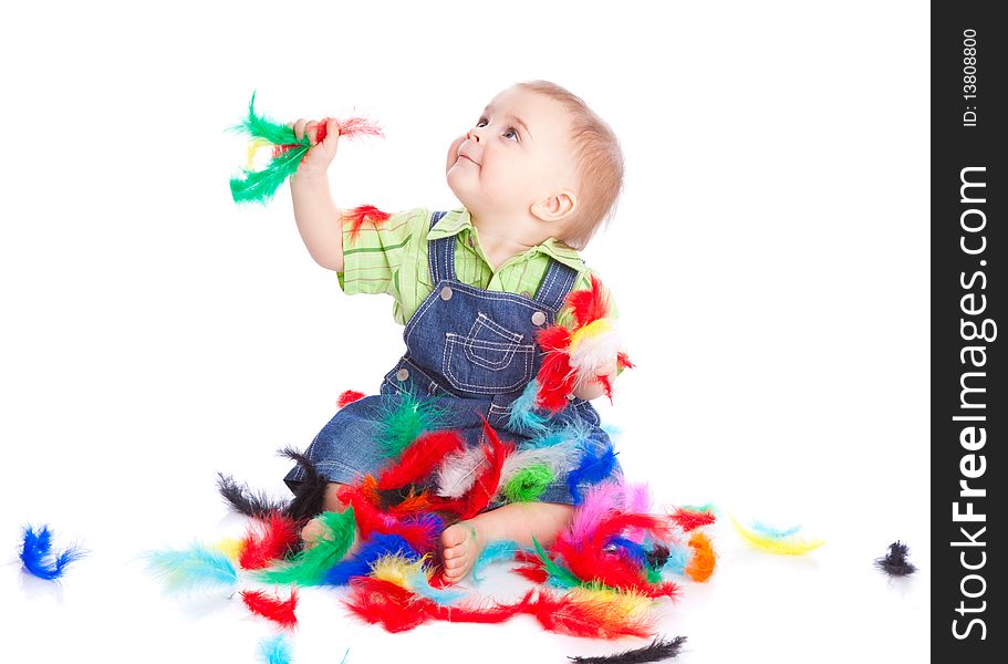 Little boy is sitting on a flow with feathers