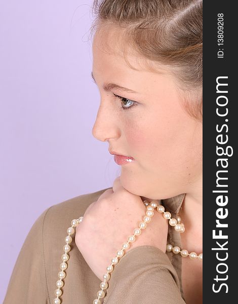 Beautiful teenage female against purple background, wearing pearls. Beautiful teenage female against purple background, wearing pearls