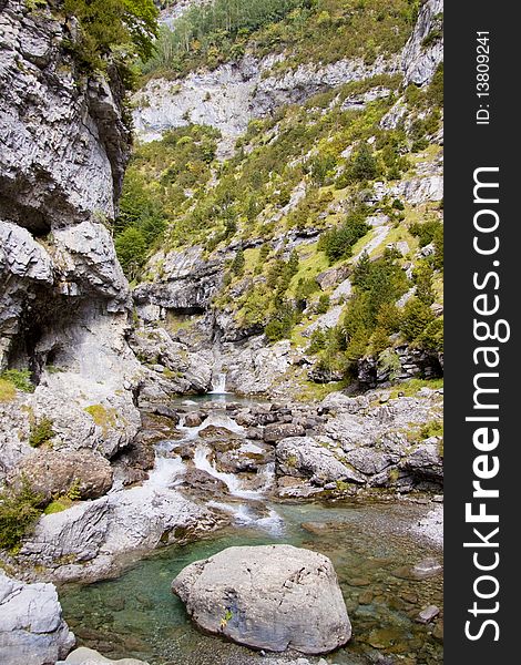 River Bellos in big Canyon Anisclo  - Ordesa Nation Park in Pyrenees, Spain.Autumn sunny day. River Bellos in big Canyon Anisclo  - Ordesa Nation Park in Pyrenees, Spain.Autumn sunny day.