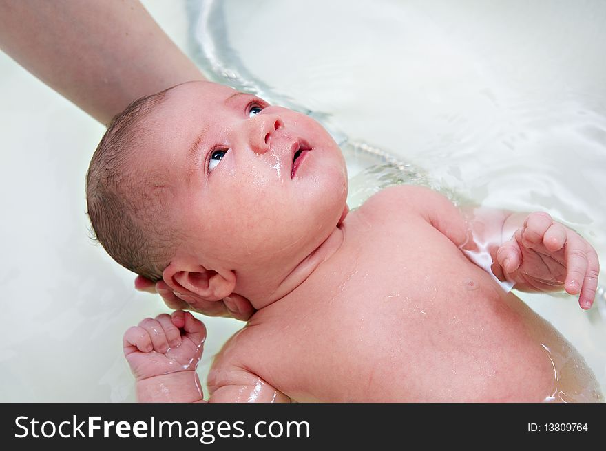 Bathing a little kid in white bath