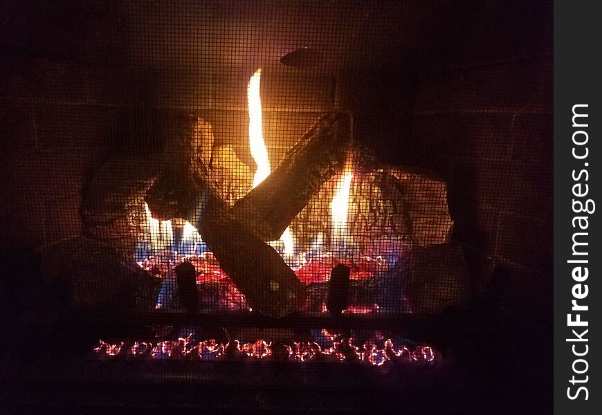 Gas fireplace with flame and fire and logs and metal grate