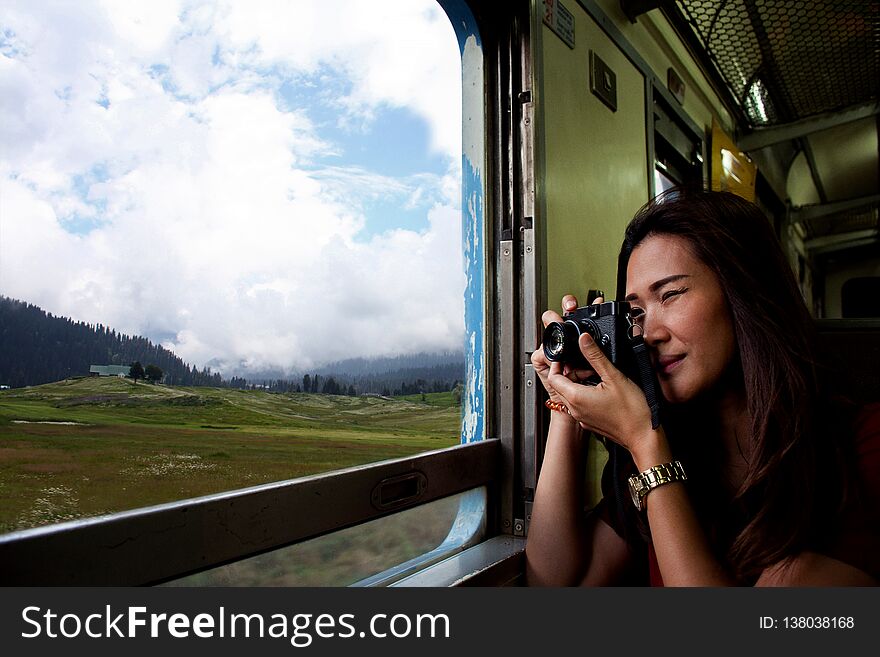 ฺBeautiful Asian woman makes a photo through from the train window