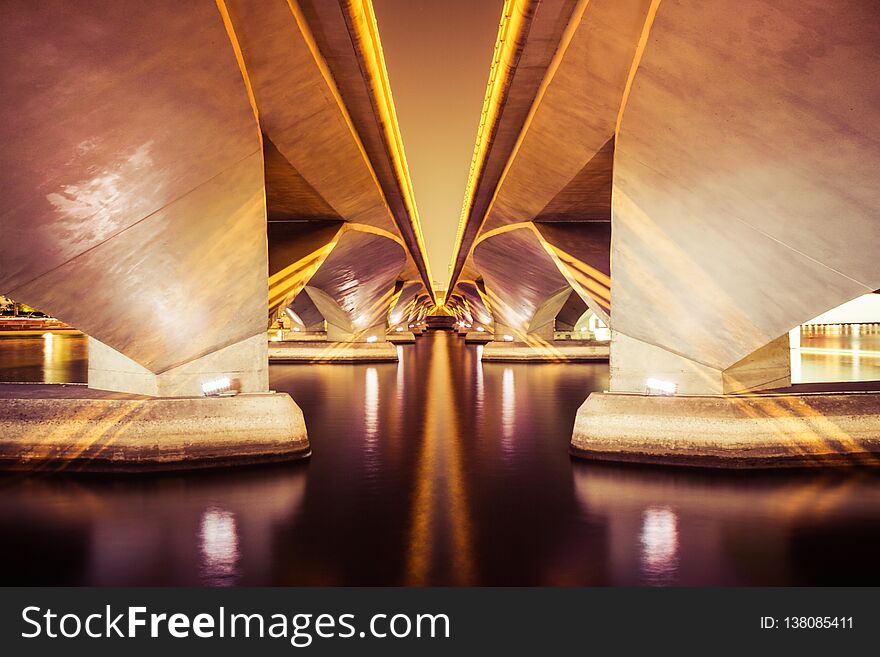 Symmetric Bridge Over Water At Night In Black And White