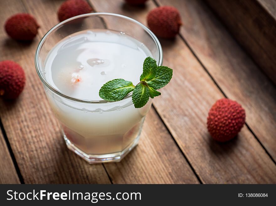 Old fahioned lychee cocktail on the rustic background. Selective focus. Shallow depth of field.