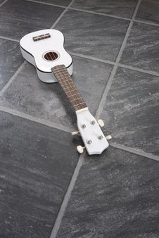 White Ukulele, Black Floor Royalty Free Stock Image