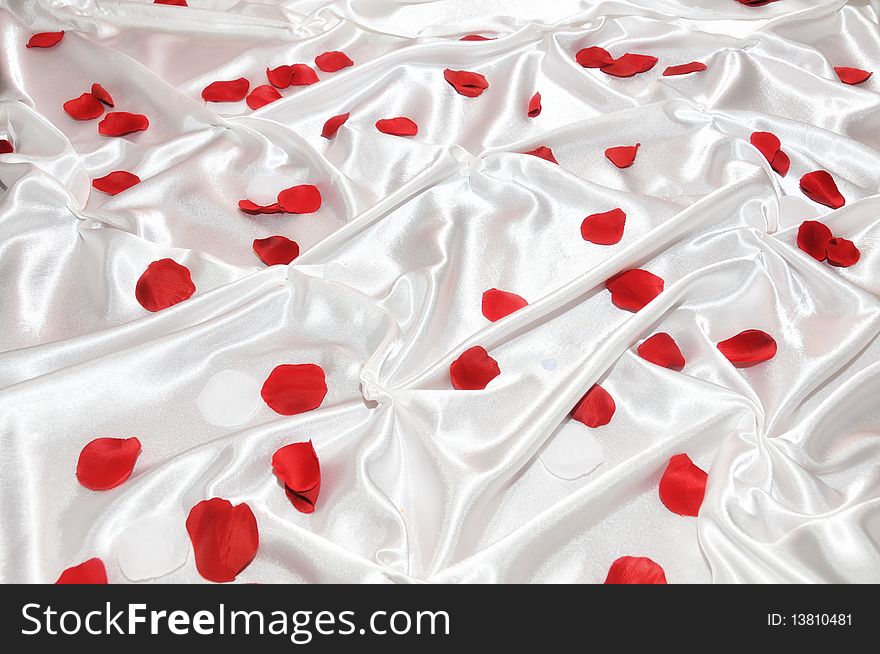 Red roses petals on white silk. Red roses petals on white silk.