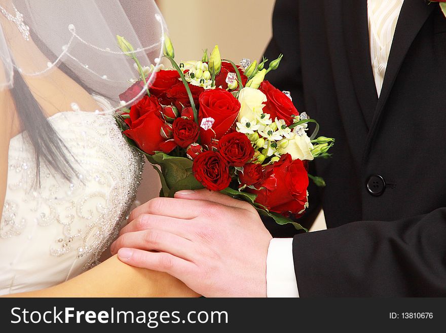 Bride and groom with red rose bouquet holding hands. Bride and groom with red rose bouquet holding hands.