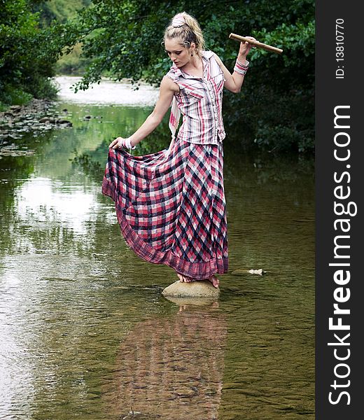Beautiful young girl with fife playing near river