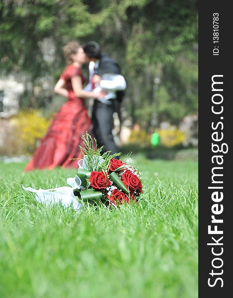 Bride and groom blured and their bouquet in grass