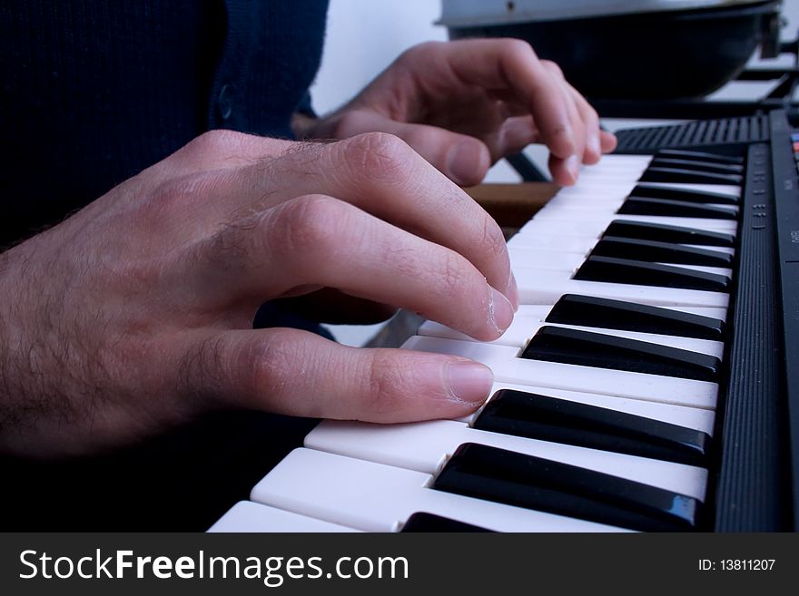 Male hands pressing the keys on an electric keyboard. Male hands pressing the keys on an electric keyboard.