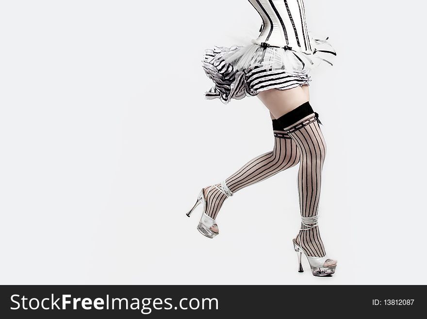Female feet, the escaping girl high-heeled on a white background