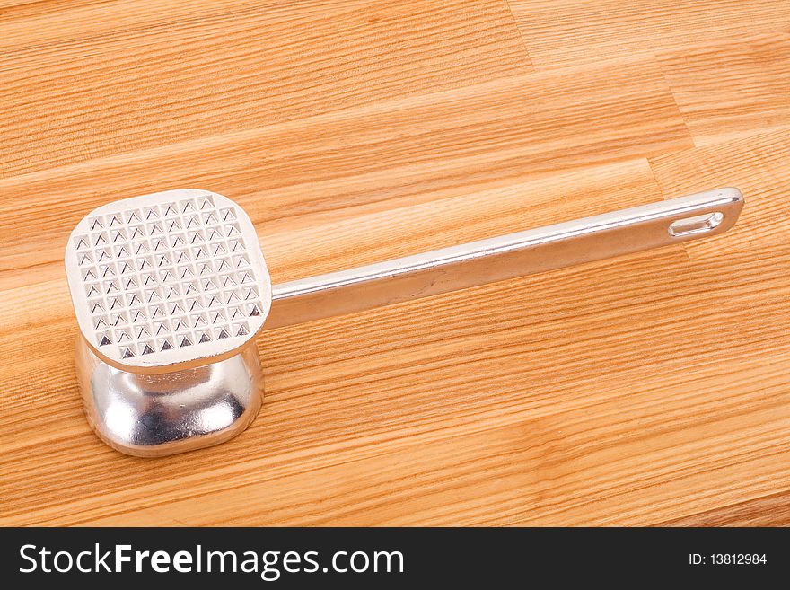 Series. aluminium meat tenderizer isolated on wooden background. Series. aluminium meat tenderizer isolated on wooden background.