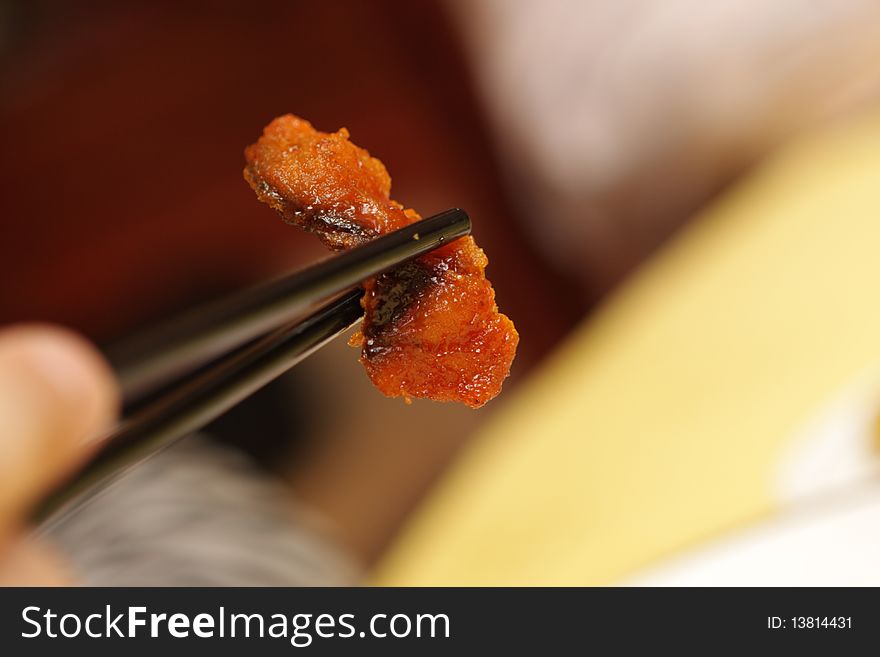 A man holding meat by chopsticks at chinese restaurant, Beijing. A man holding meat by chopsticks at chinese restaurant, Beijing