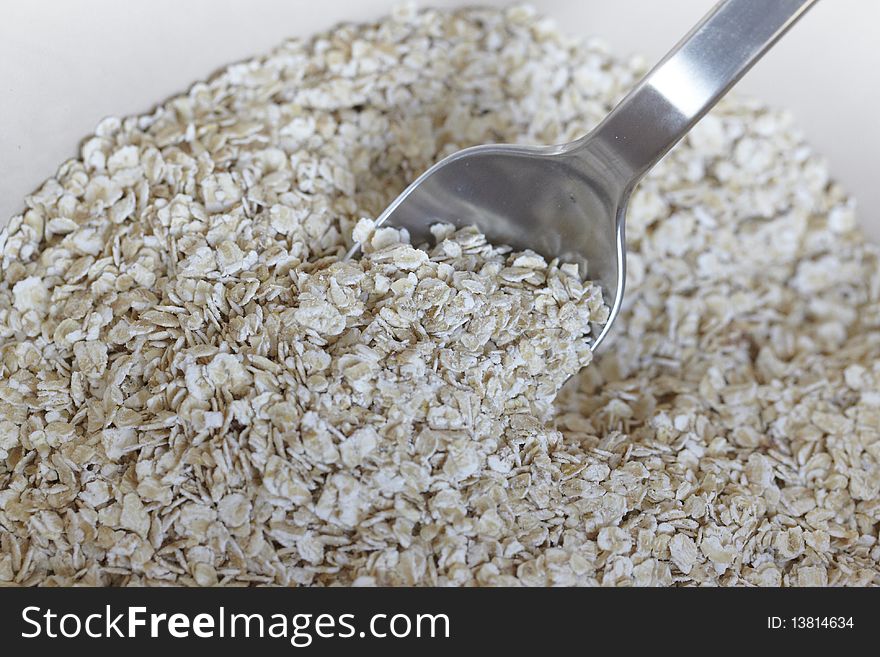Oatmeal or porridge in a bowl with a silver spoon.