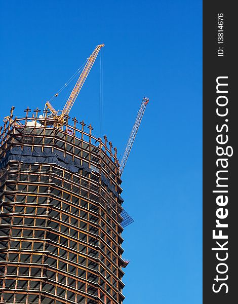 A skyscraper construction site over a blue sky