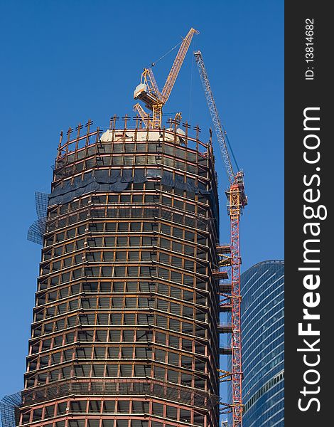 A skyscraper construction site over a blue sky